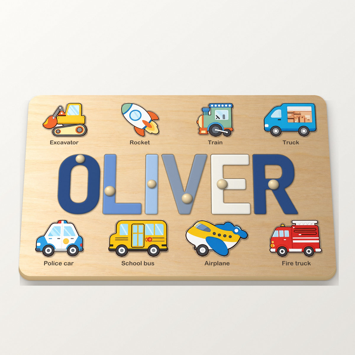 Namnpussel i trä med namnet OLIVER i blå bokstäver och åtta fordonsbilder